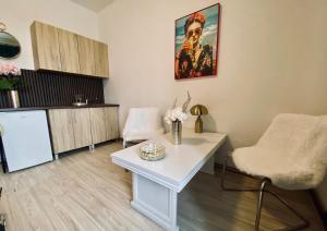 a living room with a white table and a refrigerator at Old Town Studio - Stay Olomouc CZ in Olomouc