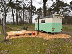 a green and white trailer parked in a park at PipowagenTwente 'n Bergven in Lattrop
