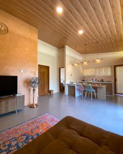 a living room with a couch and a kitchen at Los Londos Batukaras in Cijulang Nusawiru Airport