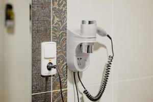 a phone is hanging on a wall in a bathroom at Hotel Polo in Prešov +56 photos