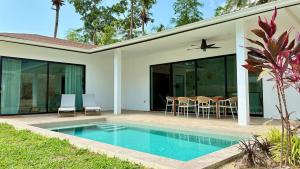 a house with a swimming pool in front of a house at Samma Villas - Ruby Villa - 2 BDR & private pool in Ko Phangan