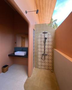 a bathroom with a shower with a sink and a mirror at Los Londos Batukaras in Cijulang Nusawiru Airport +21 photos