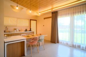 a kitchen with a large window and a table and chairs at Los Londos Batukaras in Cijulang Nusawiru Airport