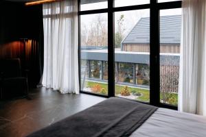 a bedroom with a large window with a view of a yard at Relax Resort in Reshetilovskiy Kut +98 photos