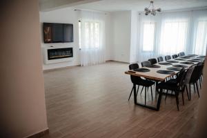 a dining room with a long table and chairs at Armonia -Rucar in Podu Dîmboviţei
