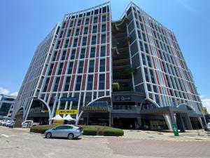a large building with a car parked in front of it at Inap II, Suterabay By Ayuhouz in Kota Kinabalu