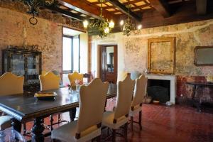 a dining room with a table and chairs and a fireplace at Red Palazzo Fossanova in Priverno