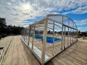 a glass house with a swimming pool in it at Złociste Zacisze in Bobolin