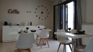 a kitchen with a white table and white chairs at La Maison du Coeur in Bari