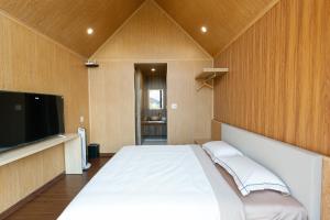 a bedroom with a bed and a flat screen tv at Zenora Homestay in Khu Chi Lăng