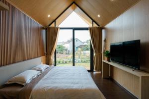 a bedroom with a large bed and a tv at Zenora Homestay in Khu Chi Lăng