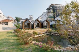 a house with a pond in a yard at Zenora Homestay in Khu Chi Lăng +9 photos