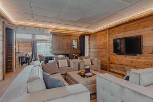 a living room with white furniture and a flat screen tv at Ultima Hotel Courchevel in Courchevel