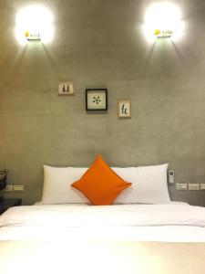sypialnia z łóżkiem z dwoma światłami na ścianie w obiekcie David Samstrong Lite 小馬客棧 果園 w mieście Chenggong
