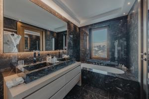 a bathroom with two sinks and a large mirror at Ultima Hotel Courchevel in Courchevel +55 photos