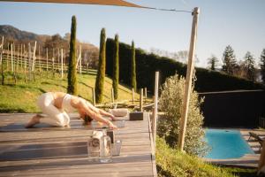 a woman doing yoga on a deck next to a pool at Landpalais Goyenhof - Deluxe Suites & Breakfast in Schenna +54 photos