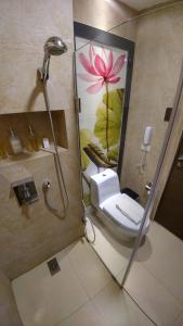 a bathroom with a toilet and a painting of a flower at Boracay Haven Suites in Boracay