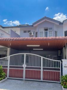 a house with a white fence and a red gate at Rex Zone Homestay in Bedung