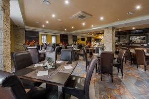 a restaurant with tables and chairs and a bar at Hotel Polo in Prešov