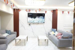 a living room with two couches and a flat screen tv at Pr Pyramids Inn in Cairo