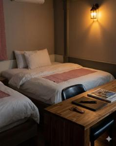 a room with two beds and a wooden desk with a desk at Hiddenhill Bulkuksa Hotel in Gyeongju