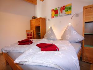 a bed with two red pillows on top of it at Semi-detached house, Zingst in Zingst