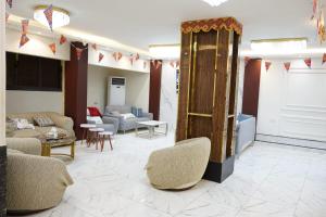 a living room with couches and chairs and a table at Pr Pyramids Inn in Cairo