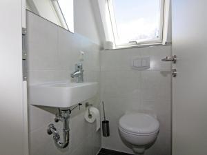 a bathroom with a sink and a toilet with a window at Semi-detached house, Zingst in Zingst