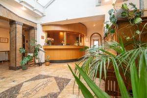 a lobby of a building with plants in the foreground at Hotel Zur Traube in Velbert