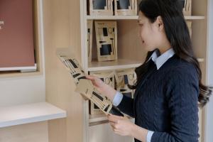 a woman is reading a book in a book shelf at Anook Hotel Jungangro Station in Daejeon