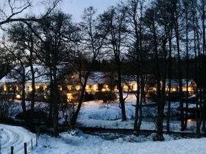 a building is lit up in the snow at Östra Nyrups Lantliv in Höör