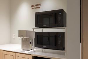 two microwaves are on a shelf in a kitchen at Anook Hotel Jungangro Station in Daejeon