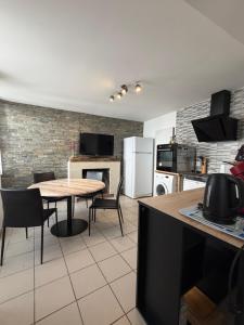 a kitchen with a table and chairs in a room at La Baraque de Beauval in Saint-Aignan