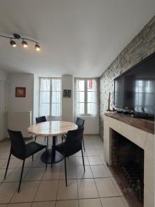 a dining room with a table and chairs and a fireplace at La Baraque de Beauval in Saint-Aignan