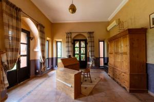 a living room with a wooden cabinet and a table at Dar Mardan in El Aggada