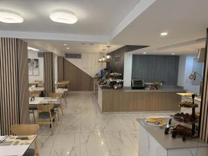a restaurant with tables and chairs and a counter at Best Western Plus Larco Hotel in Larnaca