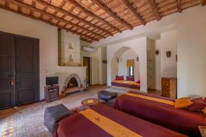 a living room with two beds and a fireplace at Dar Mardan in El Aggada +36 photos