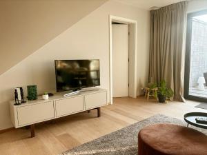 a living room with a flat screen tv on a cabinet at La Rosière en Gaume in Musson