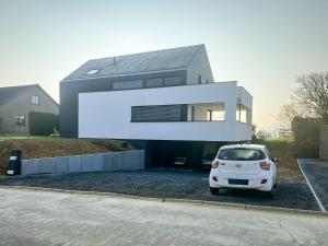 a white car parked in front of a house at La Rosière en Gaume in Musson