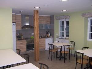 a kitchen and dining room with tables and chairs at mundoalbergue in Santiago de Compostela