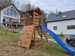 a playground with a ladder and a slide at Domki na Lubczykowej in Ostre