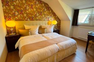 a bedroom with a large bed with a floral wall at Boutique Hotel Restaurant Hollerather Hof in Hellenthal