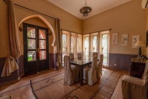 a dining room with a table and chairs and a window at Dar Mardan in El Aggada