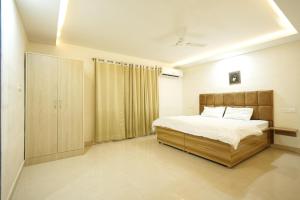 a bedroom with a large bed and a closet at Greek House By Housiify in Gurgaon +74 photos