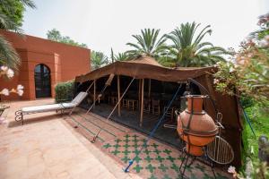 a pavilion with a table and a vase on a patio at Dar Mardan in El Aggada