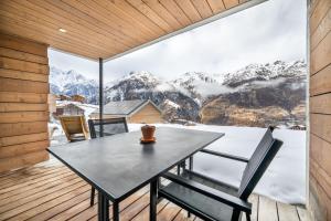 a dining room with a table and a view of mountains at Schwarzhornblick in Grächen