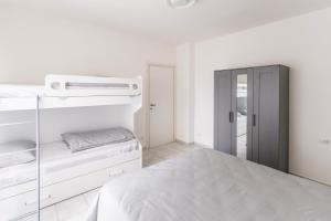 a white bedroom with a bed and a mirror at Alpoggiouno in Vercurago
