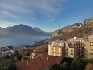 a view of a city with mountains and a body of water at Alpoggiouno in Vercurago