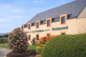 a building with a sign on the side of it at Logis Hôtel Restaurant Les Fontaines in Lanvollon +31 photos