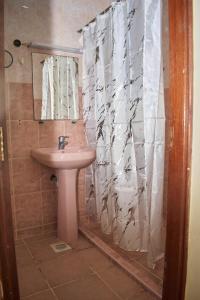 a bathroom with a sink and a shower curtain at Razz Homes in Diani Beach +6 photos